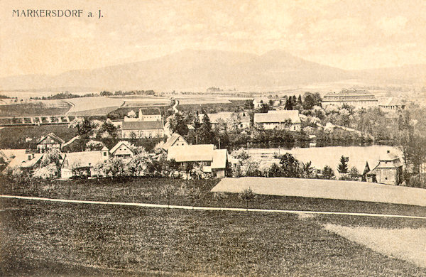 Diese Ansichtskarte von 1925 zeigt die Ortschaft mit dem Markersdorfer Teich von Süden. Im Hintergrund rechts sieht man das monumentale Gebäude des Palmeschen Hofes, am Hintergrund ist der langgezogene Hochwald und der rundhöcker des Sokol-Berges.