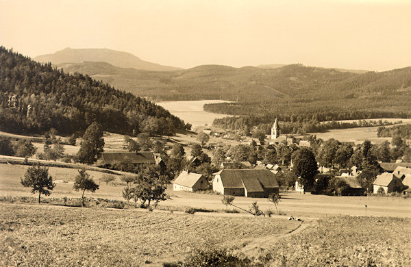 Diese Ansichtskarte aus der Zeit nach dem 2. Weltkrieg bildet die Gemeinde mit der Kirche St. Pankraz im Blick vom Südosten ab. Links am Horizont ragt der lange Kamm des Hvozd (Hochwald) mit der Bergbaude und dem Aussichtsturm empor.