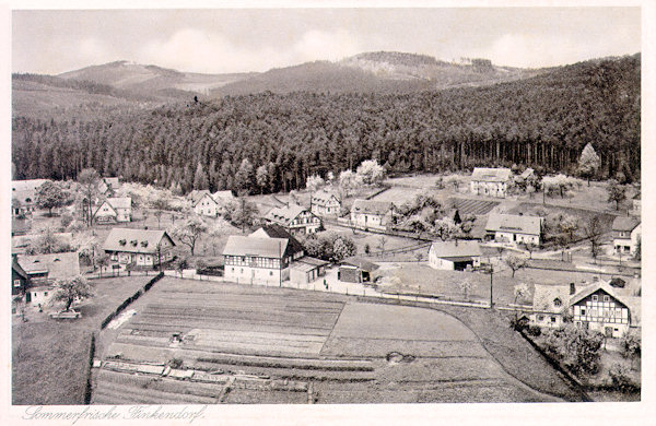 Auf dieser, vom Aussichtsfelsen Havran aufgenommenen Ansichtskarte aus der Zeit um 1930 sieht man die Häuser im Ortszentrum. Im Vordergrund steht das ehemaligen Gasthaus „Zur Stadt Reichenberg“ und unmittelbar hinter ihm das Gasthaus „Zur Quelle“, in dem sich heute die Pension „U Budulínka“ befindet. Rechts am Wald steht die heutige Pension Sportturia.