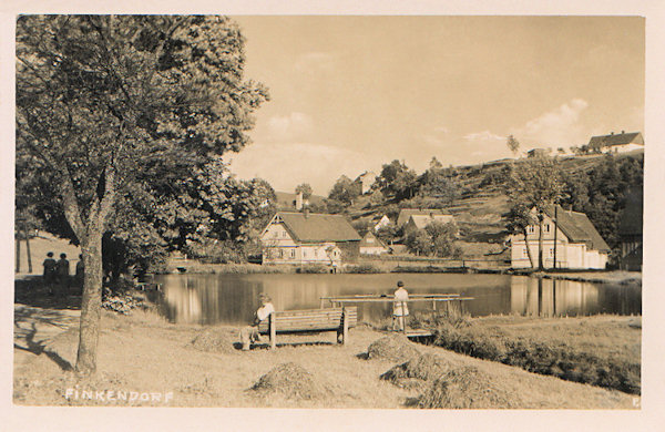 Tato pohlednice zachycuje rybník uprostřed osady, sloužící i dnes k příležitostnému koupání. Dům vpravo za rybníkem už neexistuje a svah v pozadí je zakrytý lesem.