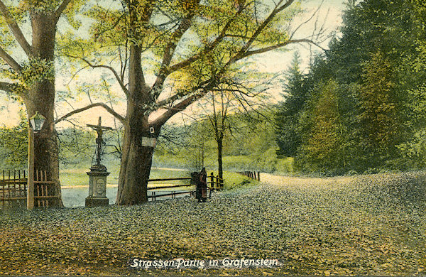 Tato pohlednice zachycuje křižovatku silnic u rybníka pod Grabštejnem. Stromy ani kříž tu dnes již nenajdeme.