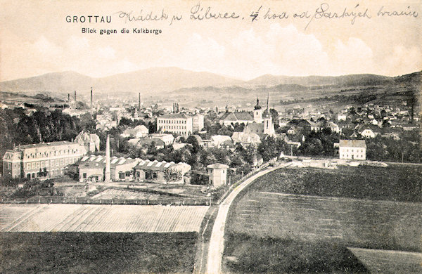 This picture postcard from 1909 shows Hrádek nad Nisou as seen from the north. On the left we see the factory buildings in the Husova ulice-street, in the field to the right of it to-day there is the Primary school. In the built-up area the acute tower of the evangelic church is standing-out, behind of it there is the church of St. Bartholomew and on the left the outstanding building of the primary school. The horizont is closed by the long ridge of the Ještědský hřbet with the Velký Vápenný hill.