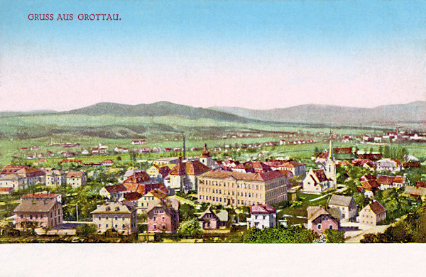 This picture postcard shows the town with its most prominent buildings: the church of St. Bartholomew on the left, the school in the centre and the Protestant church on the right side. In the background behind of the river there are the houses of Loučá village under the prominent two-peaked hill Popova skála and Sedlecký Špičák, in the right part the horizon is closed by the Heideberg hill.