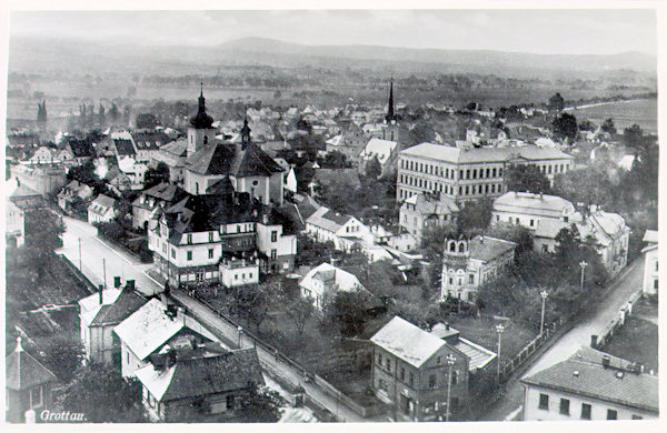 On this picture postcard from the 30s of the 20th century we see the central part of the town marked by the Liberecká ulice-street on the left and the Smetanova ulice-street on the right side. On the left side there is the church of St. Bartholomew, to the right of it the prominent building of the then primary and lower secondary school and behind of it protrudes the tower of the Protestant church.