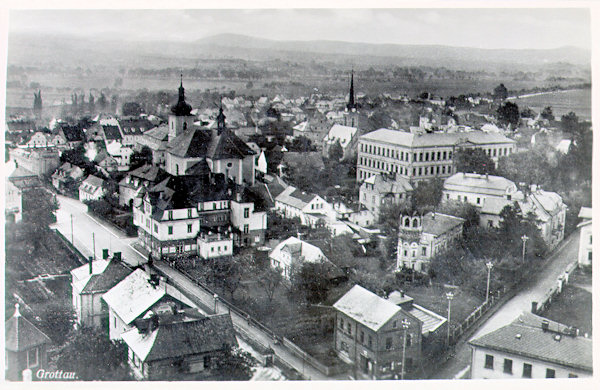 Auf dieser Ansichtskarte aus den 30er Jahren des 20. Jahrhunderts sieht man das links von der Liberecká ulice (Reichenberger Strasse) und rechts von der Smetanova ulice (Parkstrasse) begrenzte Stadtzentrum. Links ist die St. Bartholomäuskirche, rechts von ihr das imposante Gebäude der damaligen Volks- und Bürgerschule und hinter ihr strebt der Turm der evangelischen Kirche in die Höhe.