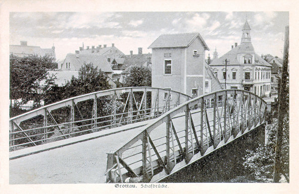 This picture postcard shows the former Ovčí most-bridge some time around 1925. In the background there is the house of the then hotel „Helgoland“ with its tower.