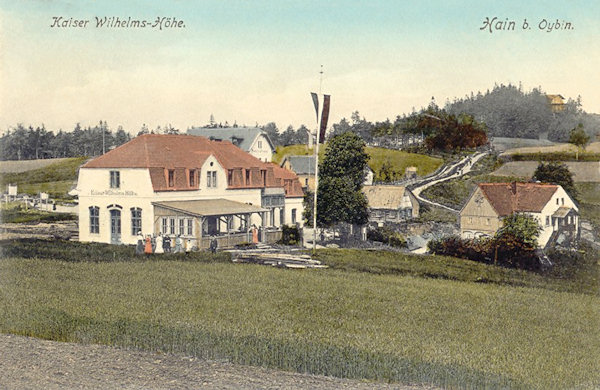 Auf dieser Ansichtskarte aus dem Jahr 1910 sieht man die am Oberende der Gemeinde dicht an der Staatsgrenze stehende Gaststätte „Kaiser Wilhelm's-Höhe“. Auf der bewaldeten Anhöhe rechts befindet sich der Johannisstein (Jánské kameny).