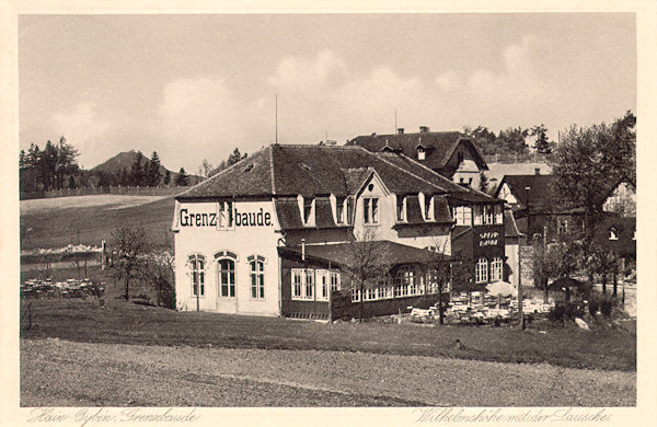 Auf dieser Ansichtskarte sieht man die Gaststätte im Sattel oberhalb der Gemeinde ungefähr um das Jahr 1930, als sie schon „Grenzbaude“ hiess. Das hinter ihr sichtbare Dach gehörte der schon auf böhmischem Gebiete stehenden Gaststätte „Franz Josef's-Höhe“.