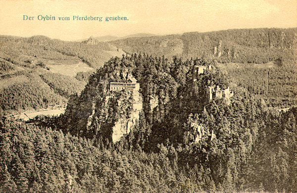 Diese Ansichtskarte aus den Jahren vor dem 1. Weltkrieg zeigt die Burg Oybin im Blick vom benachbarten Pferdeberg. Im Hintergrund erhebt sich der bewaldete Kamm des Töpfers, aus dessen tiefsten Punkte der auffallende Felsblock des Scharfensteins aufsteigt.