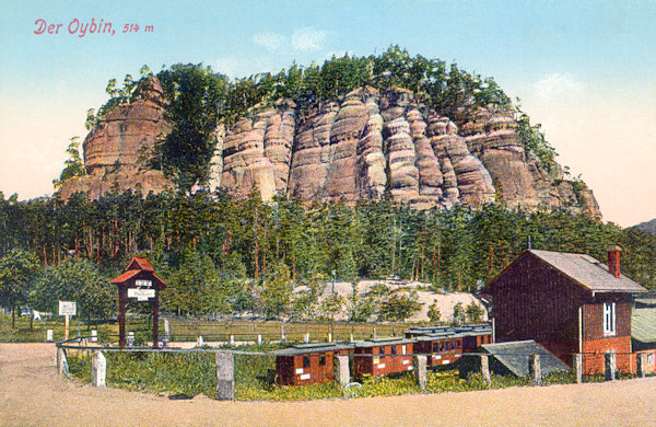 This picture postcard shows the end of the narrow-gauge railway under the monumental massif of the castle rock.