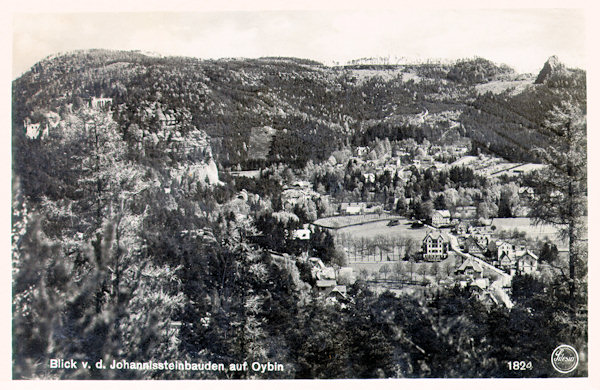 Auf dieser Ansichtskarte sieht man Oybin in der Aussicht von den Johannissteinen. Hinter dem Walde links ragt der Burgberg mit seinen Ruinen empor, hinter ihm liegt der flache Gipfel des Töpfers und ganz rechts steigt der Felsen des Scharfensteins empor.