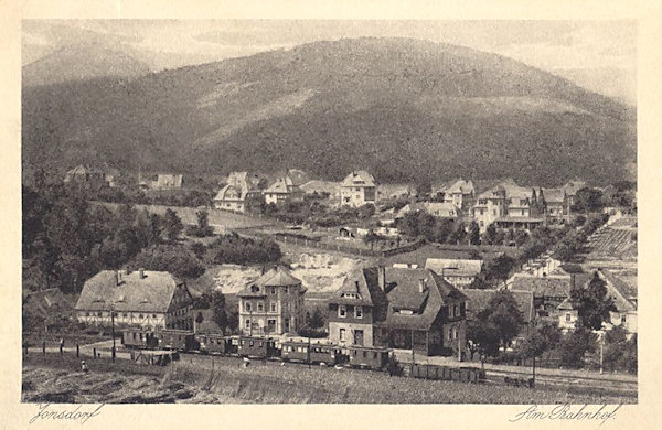 Auf dieser Ansichtskarte von 1927 ist ein Teil von Jonsdorf mit dem Bahnhof der Schmalspurbahn. Hinter der Gemeinde der Buchberg und links hinter ihm die Lausche (Luž).