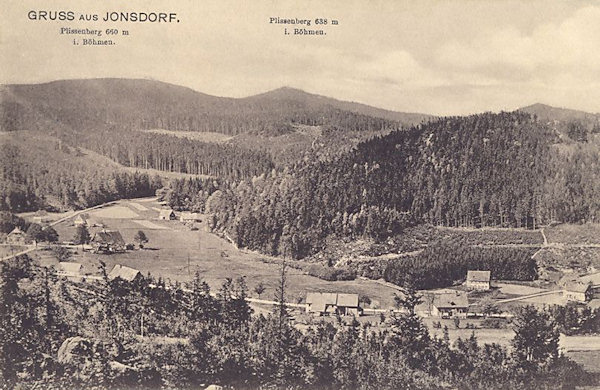 Auf der Ansichtskarte von 1912 sind die Häuser des Südendes von Jonsdorf. Die im Hintergrunde hochragenden Gipfel des Plešivec (Plissenberg) sind bereits auf der böhmischer Seite der Grenze.