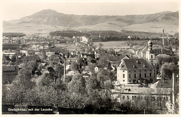 Auf dieser Ansichtskarte ist der zentrale Teil der Gemeinde mit der Kirche. Im Hintergrund ist der Bergkamm an der Grenze mit der Lausche.