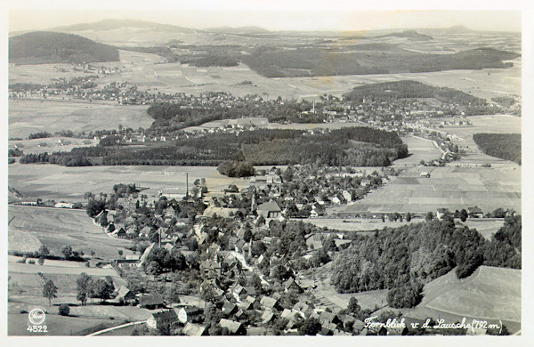Pohlednice z roku 1930 zachycuje střední a dolní část Waltersdorfu z vrcholu Luže. V širokém údolí Mandavy v pozadí je městečko Grossschönau.