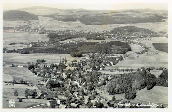 Diese Ansichtskarte aus dem Jahr 1930 zeigt den mittleren und unteren Teil von Waltersdorf im Ausblick von Gipfel der Lausche. im breiten Tal der Mandau im Hintergrund liegt das Städtchen Grossschönau.