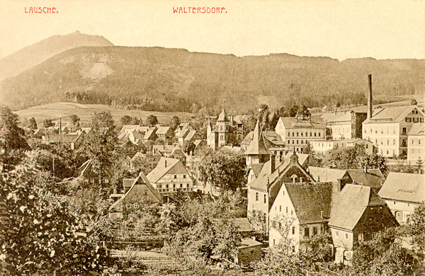 On this picture postcard from 1916 we see the village centre of Waltersdorf with the building of the post-office (with the turret) in the foreground. In the background there is the border crest with the Luž-hill.