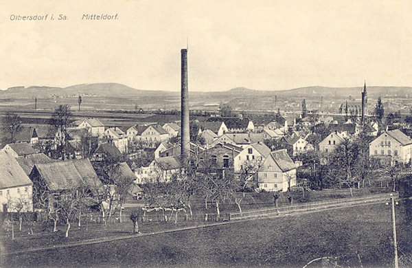 Diese Ansichtskarte von um 1910 zeigt die Ortsmitte von Süden gesehen. Im Hintergrund rechts sieht man die ehemalige Kirche.
