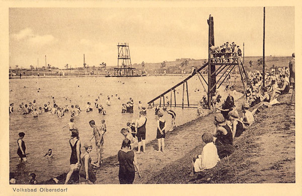 This picture postcard from the mid 20s of the 20th century shows the swimming-pool (Volksbad) with its water chute and the diving platform.