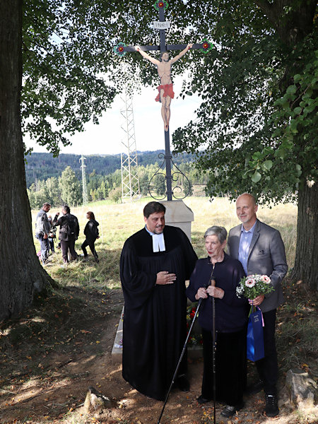 Paní Jitka Tůmová s Mgr. Richardem F. Vlasákem, M.Th. a senátorem Zbyňkem Linhartem před obnoveným křížem.