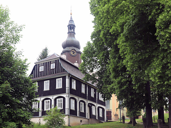 Das Gebäude des ehemaligen Pfarrhauses vor der Kirche.