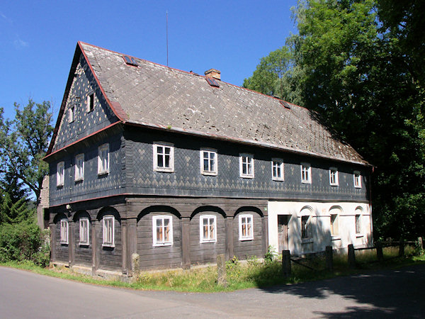 Roubený dům s břidlicí obloženým patrem v centru obce.