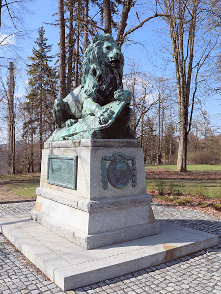 Socha lva na kraji městského parku.
