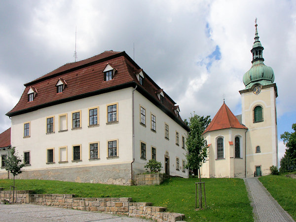 Bývalá fara s kostelem Největější Trojice na náměstí.