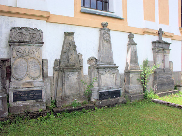 Staré náhrobky u zdi kostela.