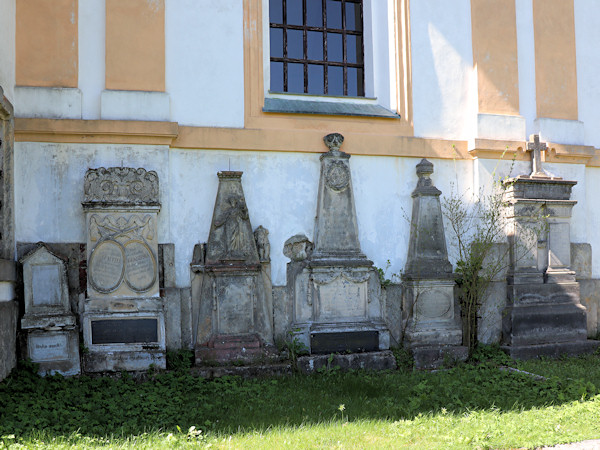 Alte Grabsteine an der Kirchenwand.