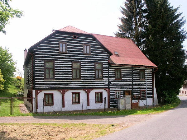Památkově chráněný roubený dům u rybníčku.