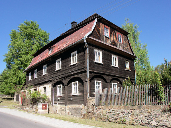 Patrový roubený dům s mansardovou střechou.