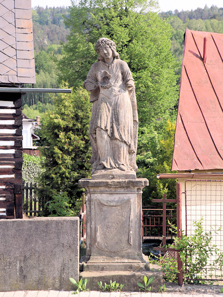 Poničená socha sv. Rozálie u mostu přes potok.