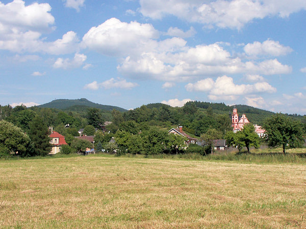 Blick auf den mittleren Teil von Mařenice (Gross Mergtal) mit der Kirche der hl. Maria Magdalena von Antonínovo Údolí (Antoniental). Im Hintergrund der Grenzberg Hvozd (Hochwald).