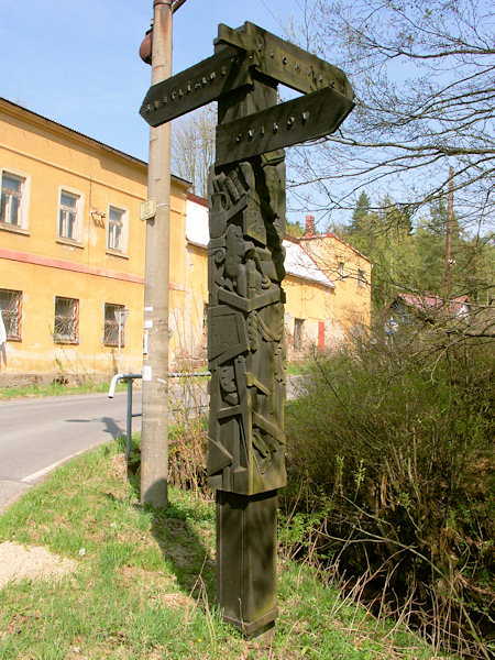 Der hölzerne Wegweiser an der Kreuzung ist das Werk des Bildhauers Josef Fojtík.