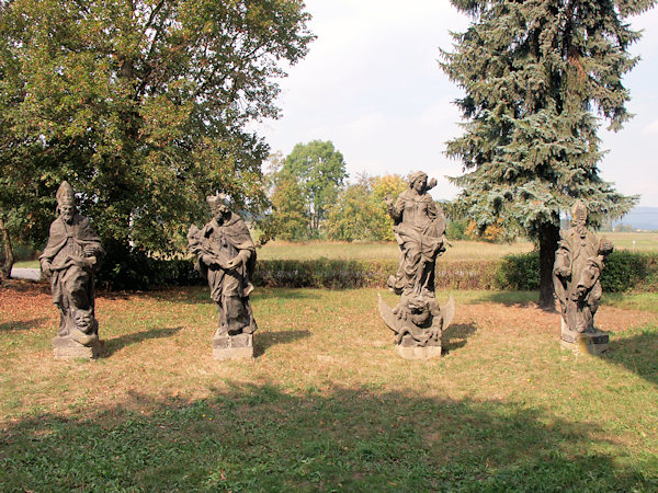 Sochy světců na bývalém hřbitově vedle kostela.