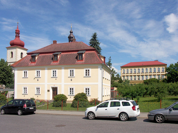 Das Pfarrhaus mit dem Turm der St. Bartholomäus-Kirche und dem Schulgebäude im Hintergrund.