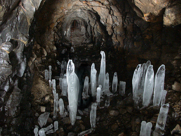 Blick in der Erkundungsstollen. Im Vordergrund befinden sich Eisgebilde, die aus abtropfendem Wasser entstanden sind.