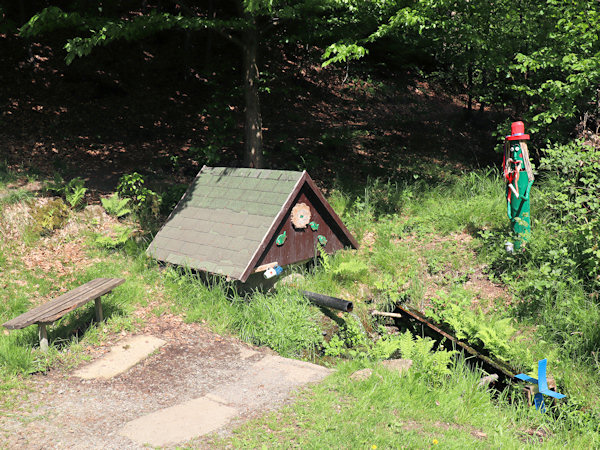 Upravená studánka na úpatí skalnatého srázu u Velenic.