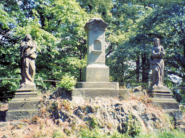 Kamenný sloup a sochy na vrcholu před zničením v roce 2000.