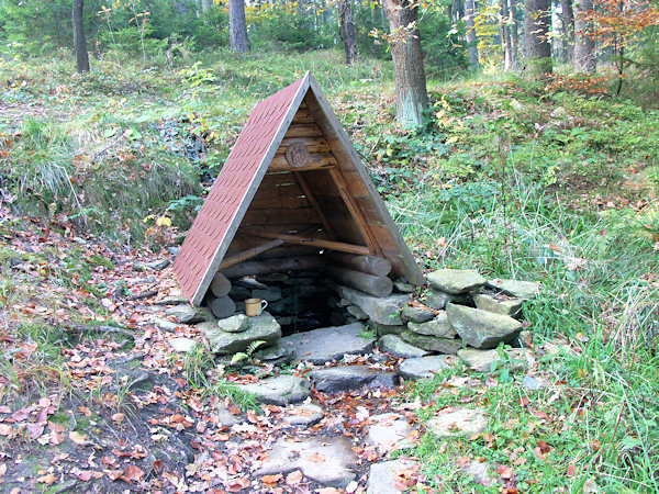 Kočičí studánka u rozcestí na severním svahu kopce.