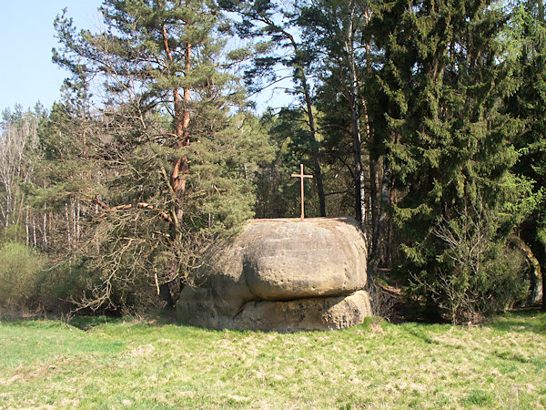 Panenská skála s dřevěným křížem na vrcholu.